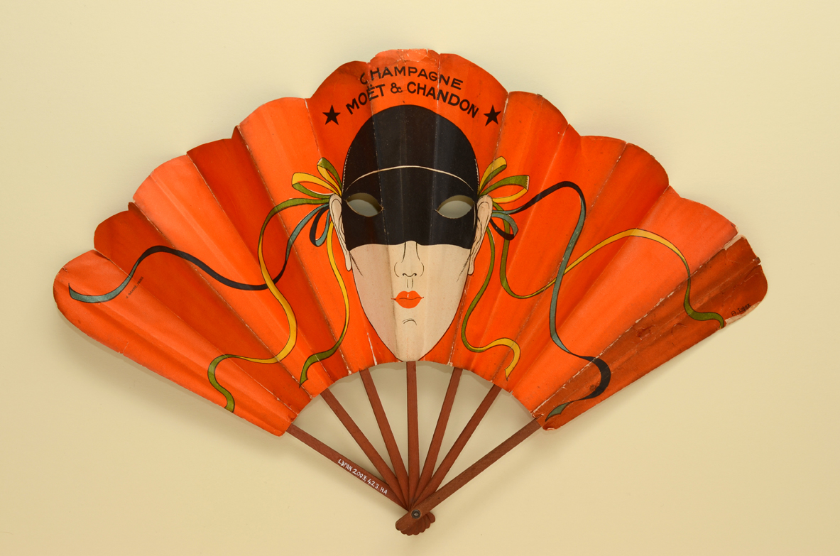 Advertising fan for Möet & Chandon Champagne. Double paper leaf printed on both sides with stylised masked female faces, signed A. LOPEZ. French, ca. 1930 The Fan Museum