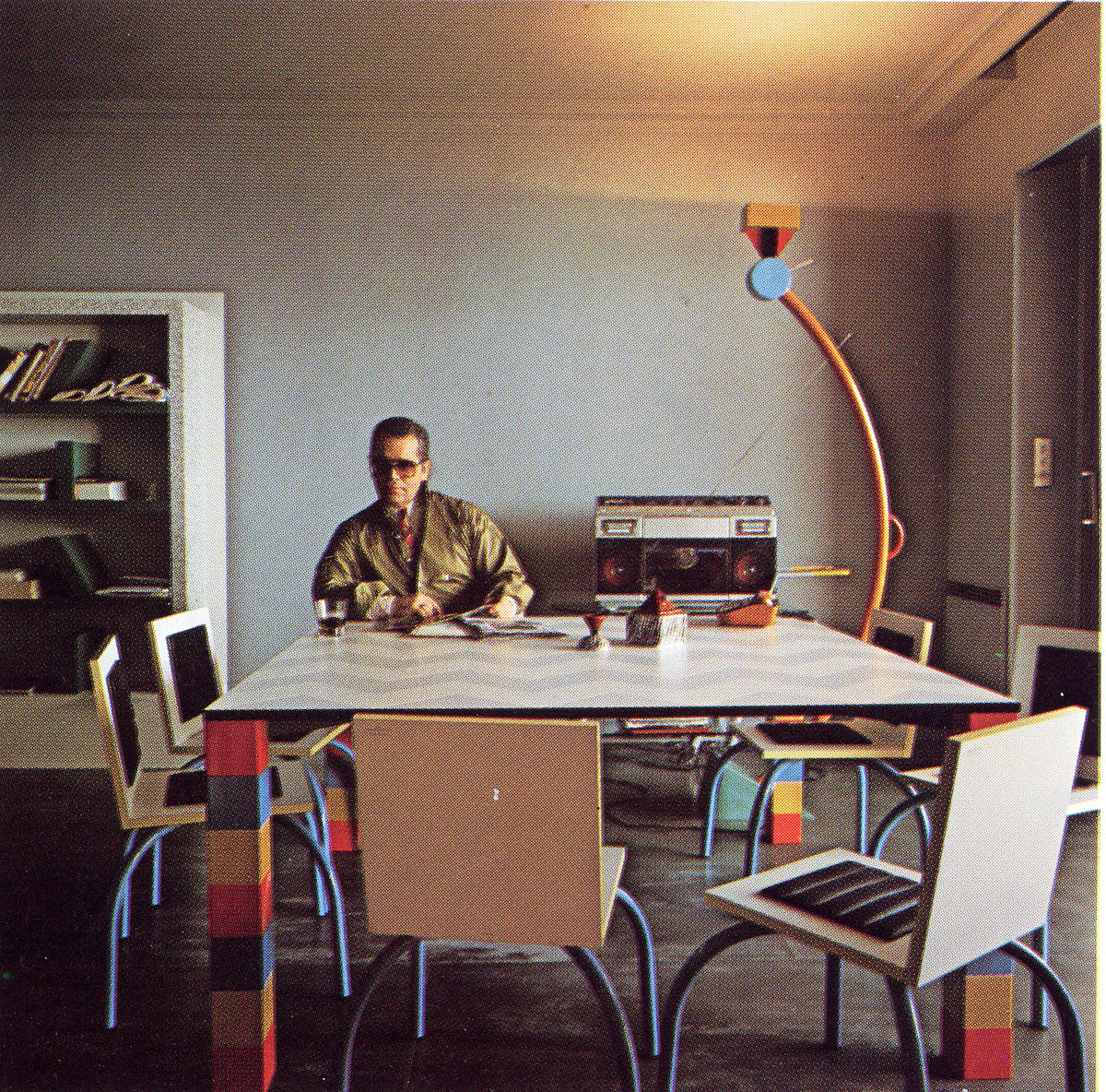 Karl Lagerfeld in his Monte Carlo apartment. “Pierre” table by Sowden, “Riviera” chair by De Lucchi, “Treetops” lamp and “Suvretta bookcase by Sottsass. Ceramics by Matteo Thun. Memphis 1981. From the book Memphis, Research, Experience, Results, Failures and Successes of the New Design by Barbara Radice, ed Electa. Photo: Jaques Schumacher. Copyright Mode & Wohnen.