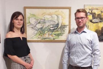 Felicitas Wagner and Florian Schweizer in front of painting "Feathered Fight"