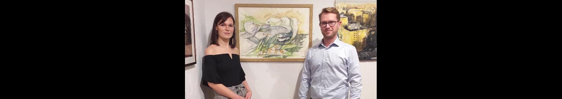 Felicitas Wagner and Florian Schweizer in front of painting "Feathered Fight"