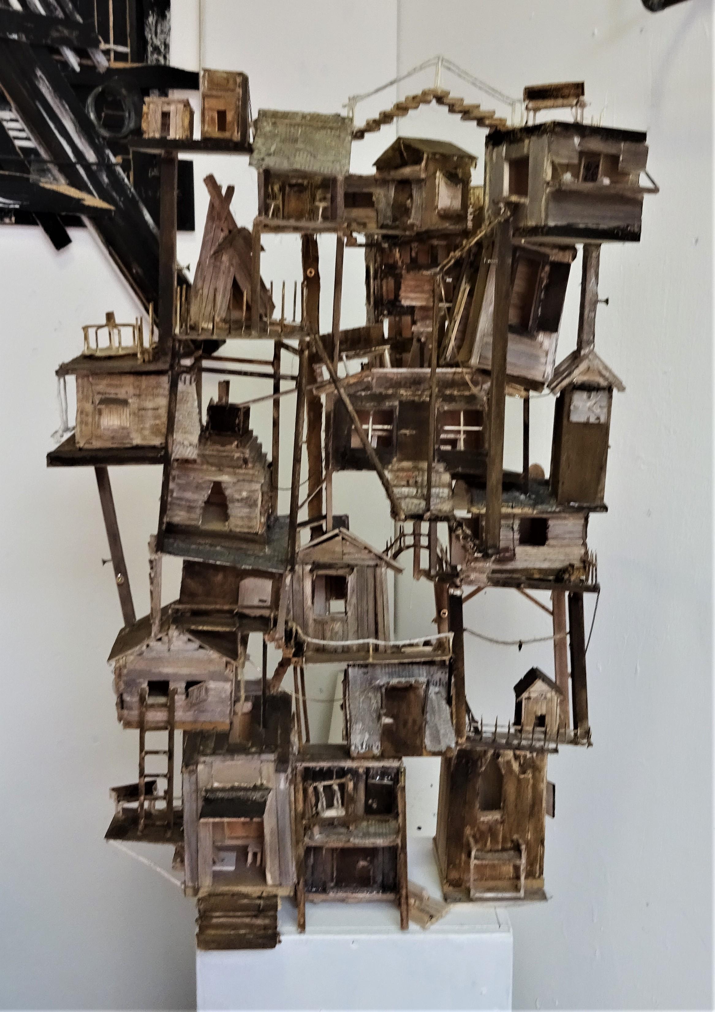 A mixed media model of lots of houses stacked on top of each other in an intricate formation 